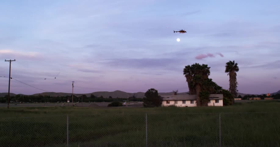 A helicopter flies over a rural country home