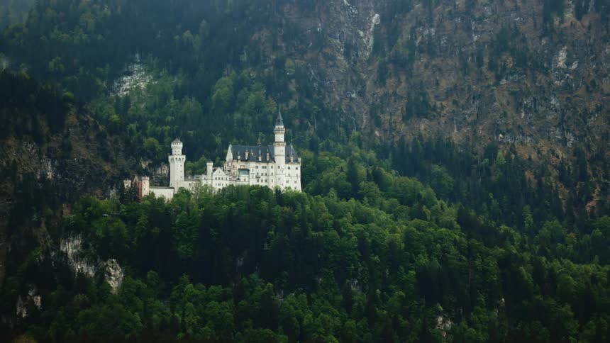 White castle on a hill hidden in the mountains