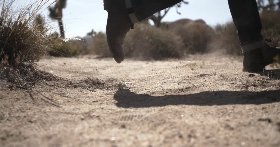 Person runs through the desert kicking dust in the air
