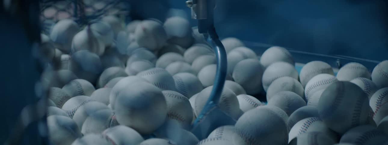 The machine mixes the bin of baseballs around
