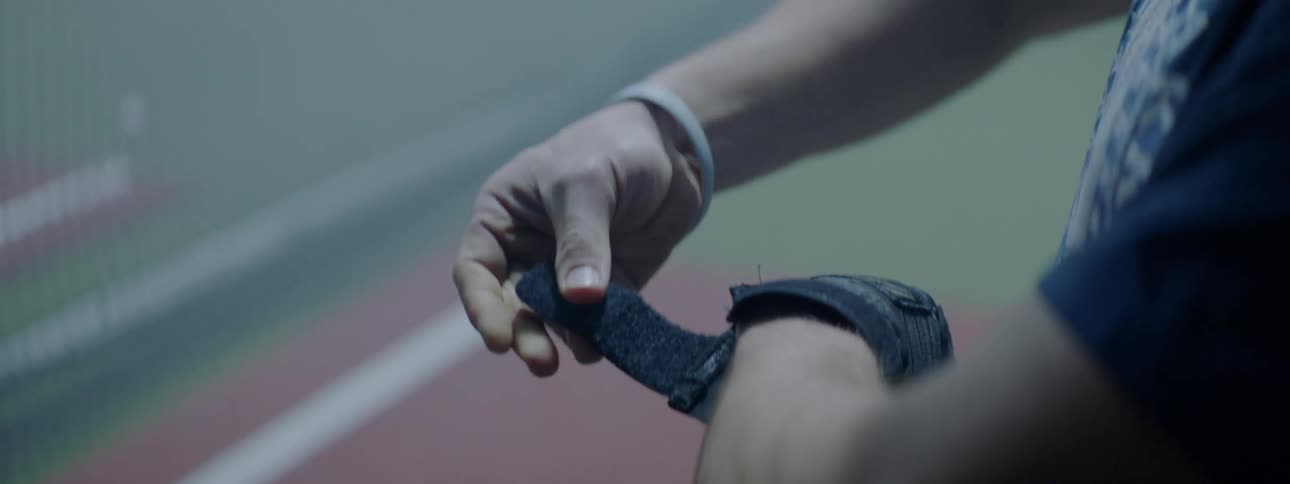 Man puts on glove with velcro on left hand