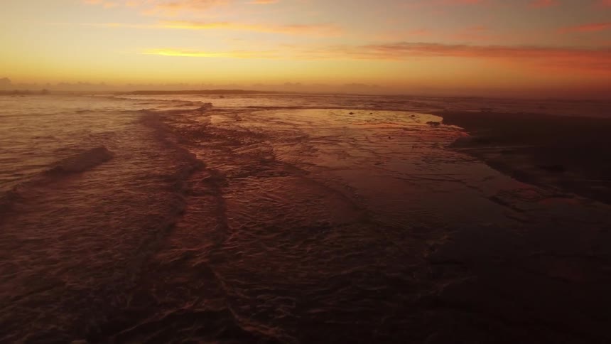 Waves flow and crash into shore at dawn