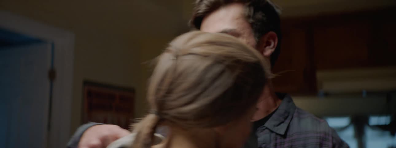 A distressed man speaks to a woman before the two embrace