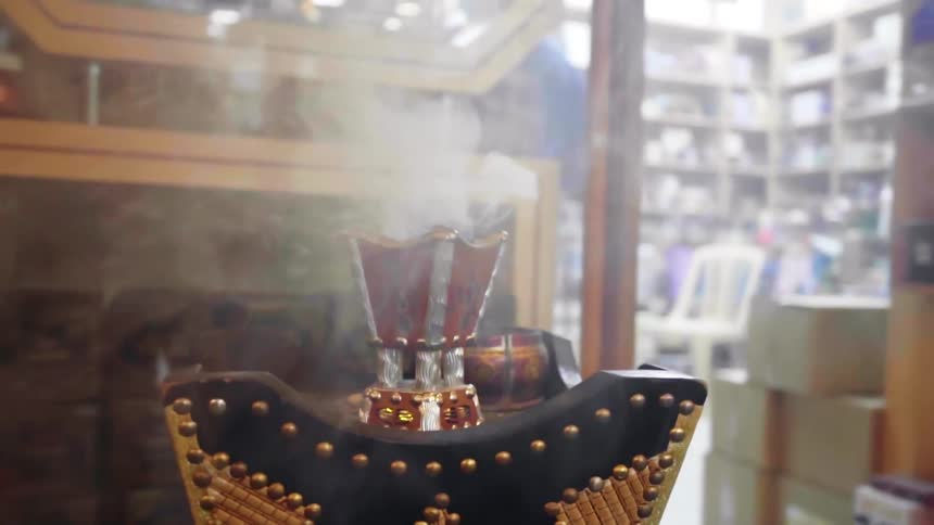 Smoke rises from center of ornate box near display shelves