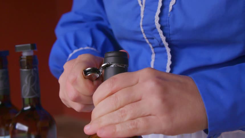 A person is opening a wine bottle
