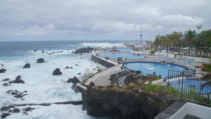A resort has multiple pools along a cliff that overlooks the ocean