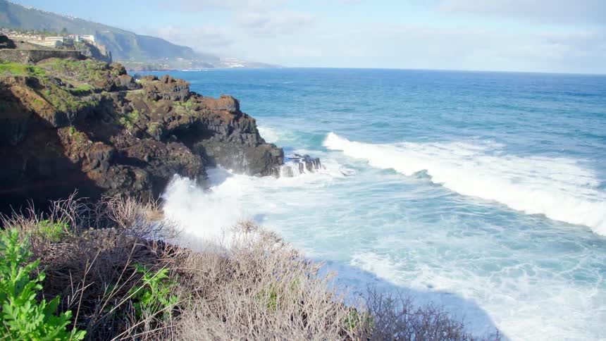 Sea waves crash against rocky shore