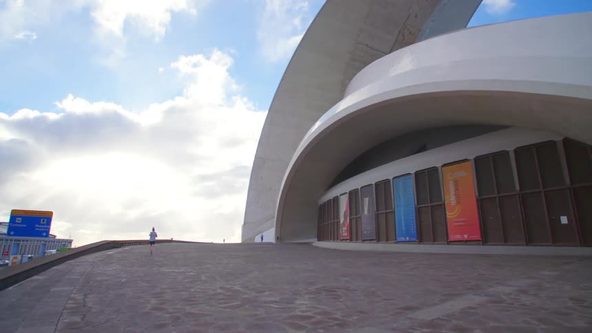 A person jogs past a large building