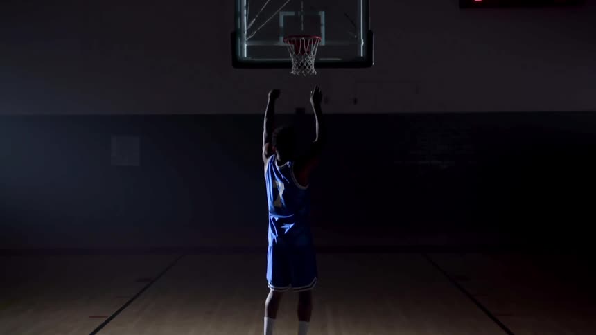 A man shots and hits a basket