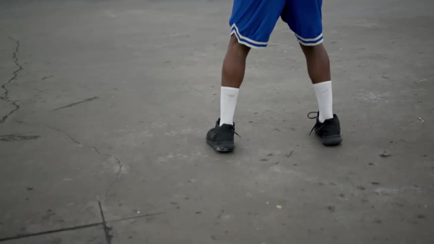 A black man dribbles a basketball