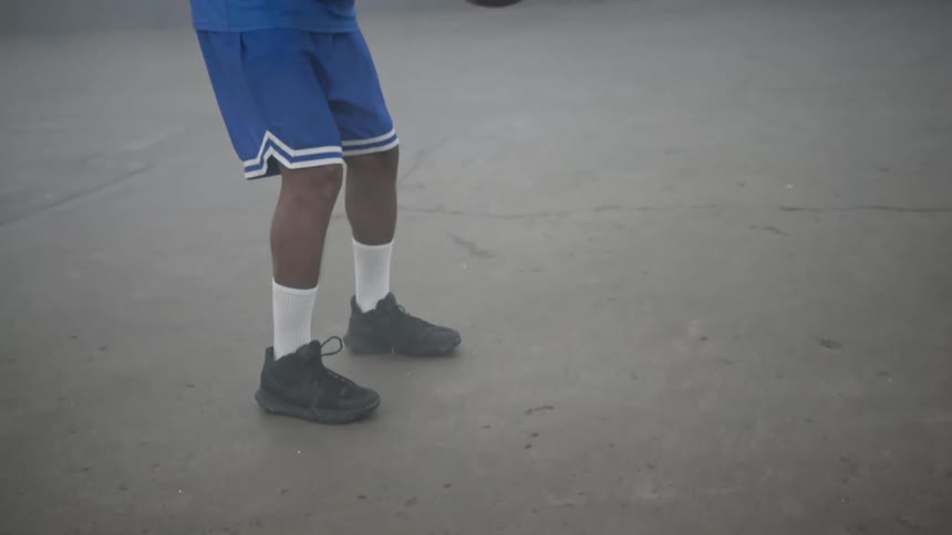 A black man dribbles a basketball