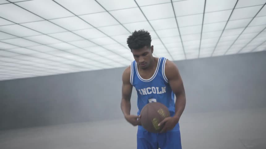 A man is bouncing the basketball around
