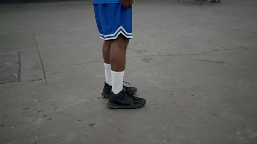 A black man standing on asphalt
