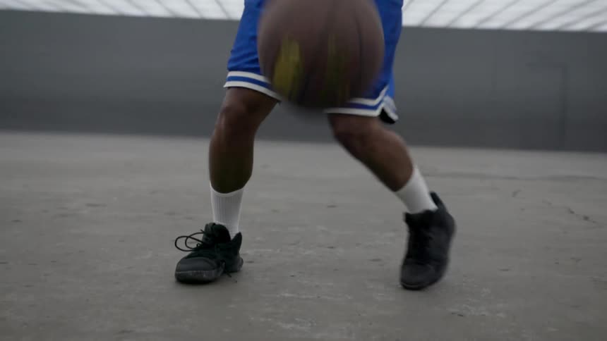 A black man dribbles a basketball