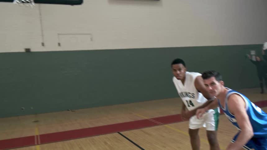 Basketball players stand at the line ready and waiting for a free throw in a tie game with one second left