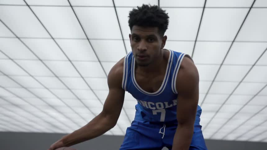 Young basketball player dribbles a basketball in a room