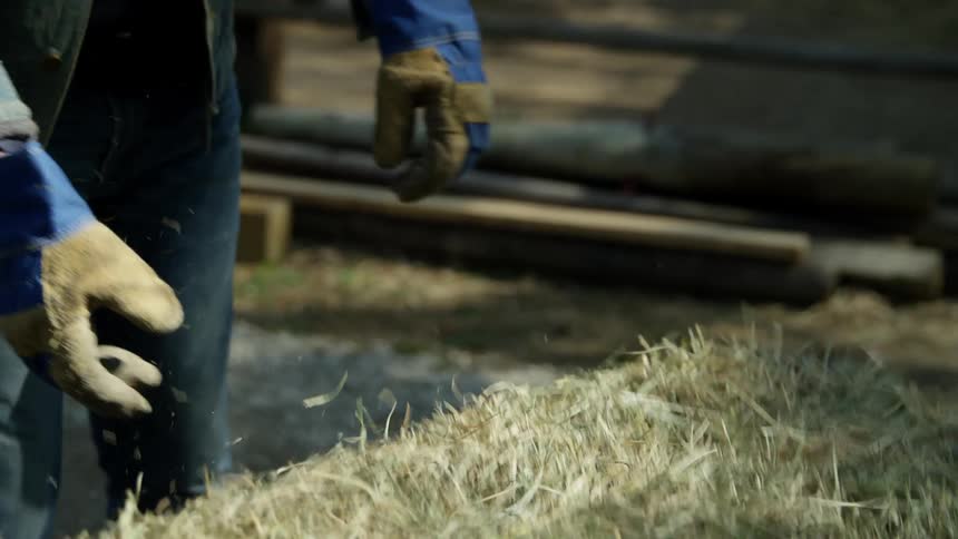 A man lifts a hay bale