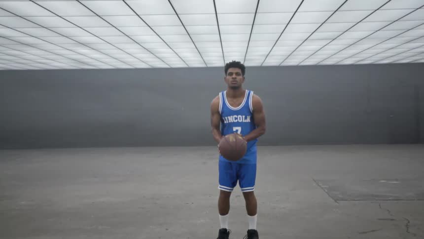 A teenager holds a basketball and takes a deep breath