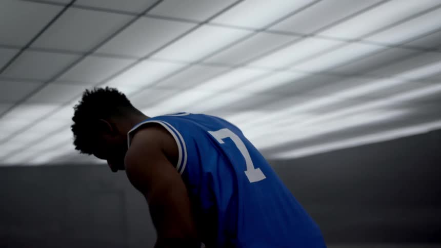 A teenager holds a basketball and takes a deep breath