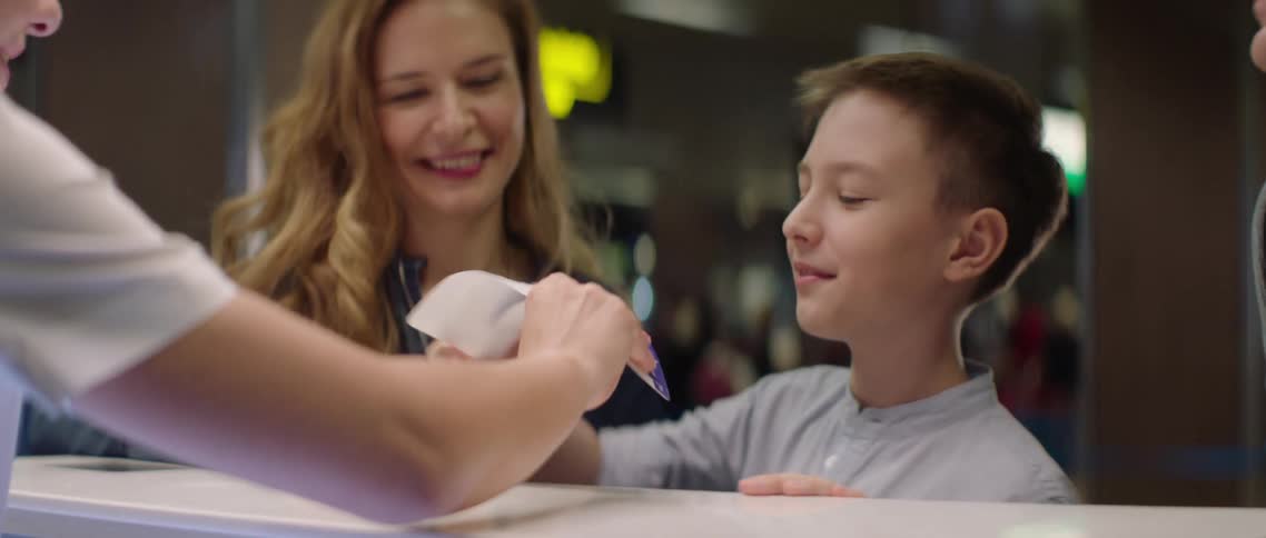 Airport clerk gives a boy a plane ticket