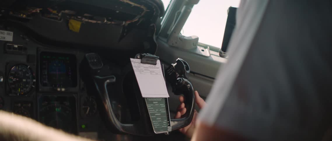 A white male pilot steers an aircraft