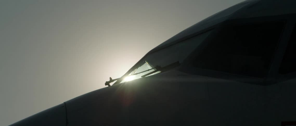 The sun shining over the front of an airplane