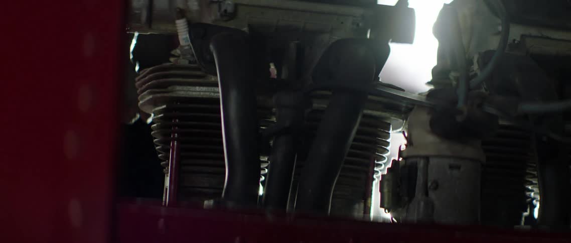 Sunlight shining through gaps in the engine of a red plane