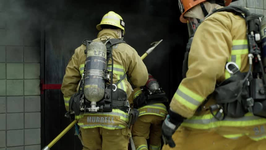 Firefighters going in to a smoking building