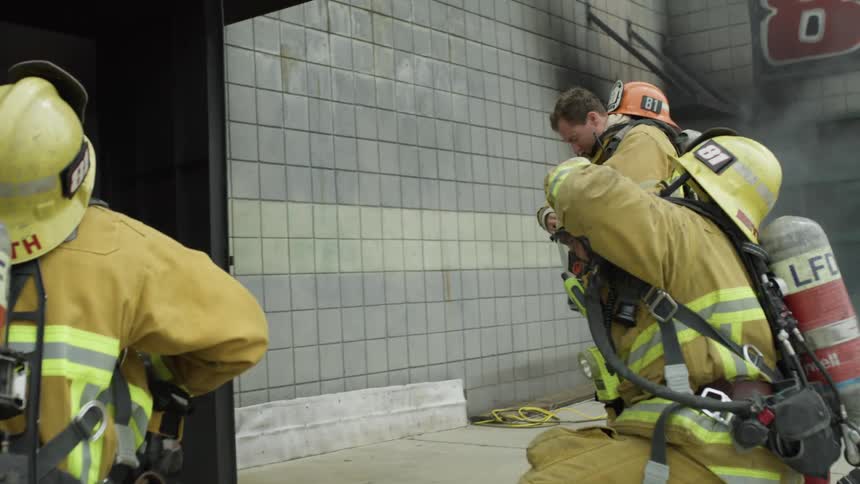 Firefighters on a training exercise get ready to enter building