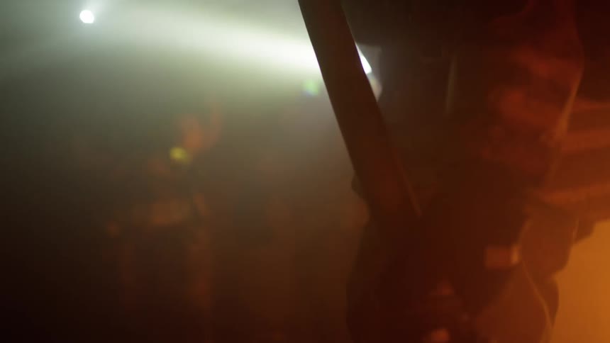 Firefighters carrying flashlights walk through a smoke filled room