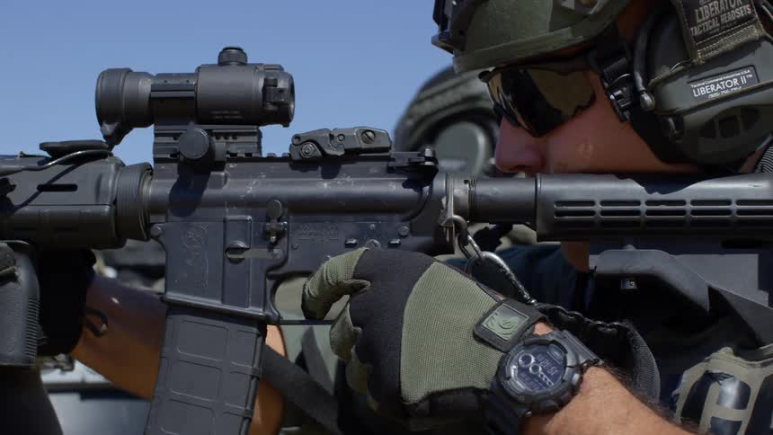 Soldiers fire their scoped rifles in a line
