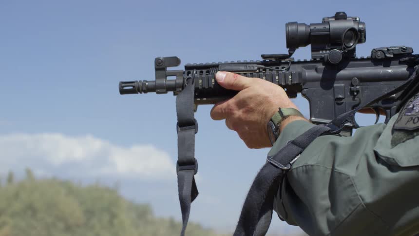 A military police aims his rifle