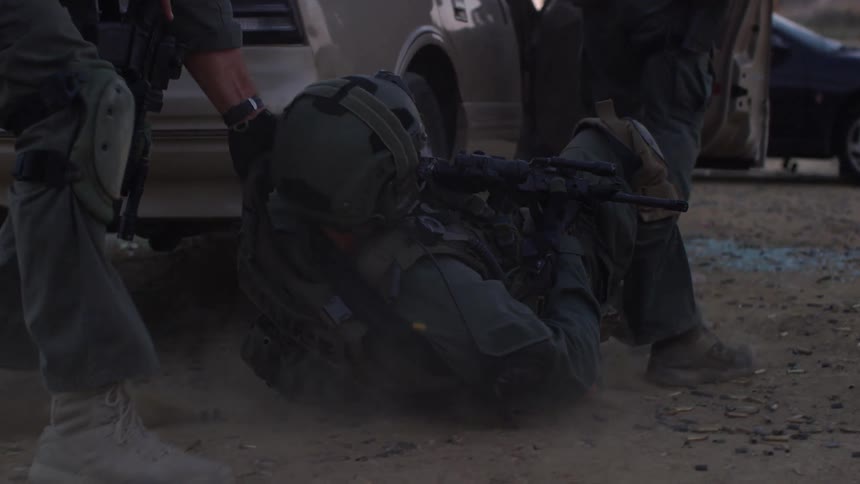 A soldier pulling another soldier behind a car