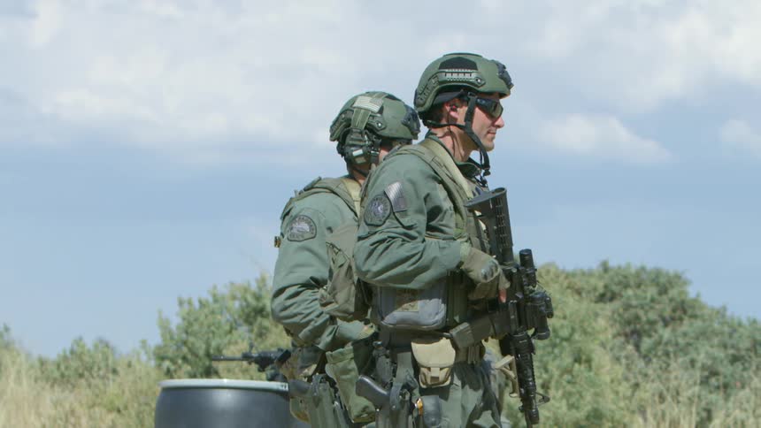 Military police walking outside with their guns