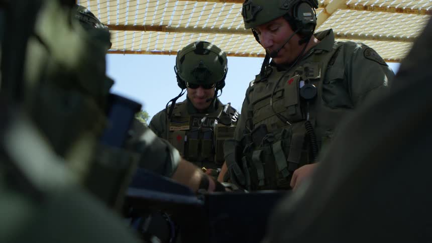 A group of police load their weapons together