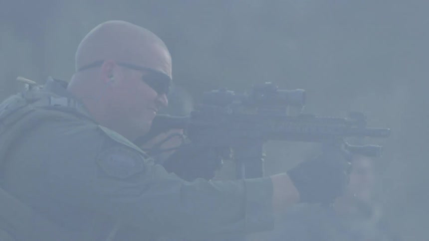 Shells eject from a military rifle as a military soldier shoots it in the fog