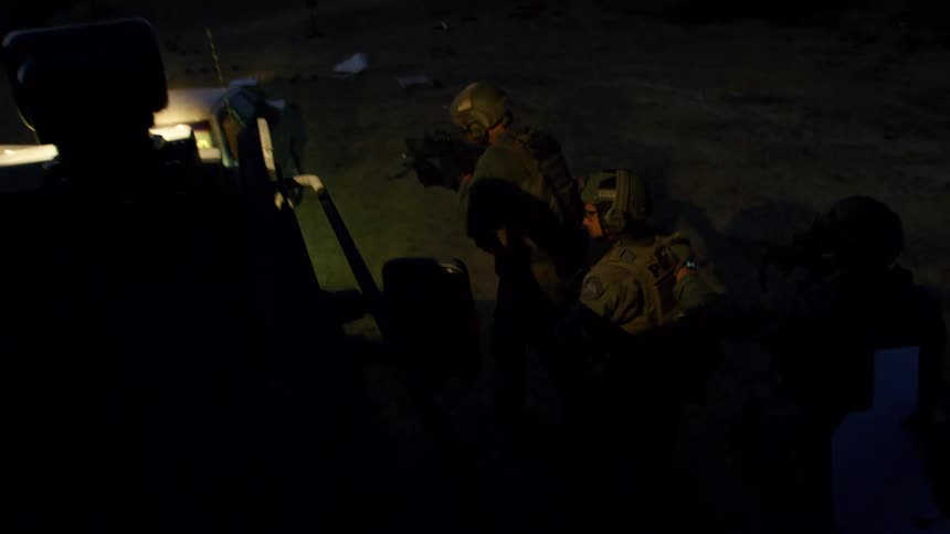 A police swat team walk backward with their guns drawn