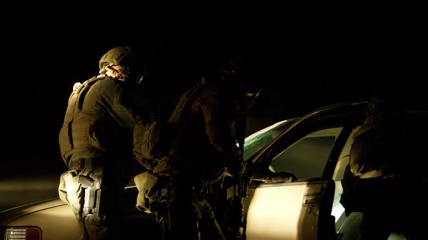 Police force in tactical gear and assault weapons on a night exercise
