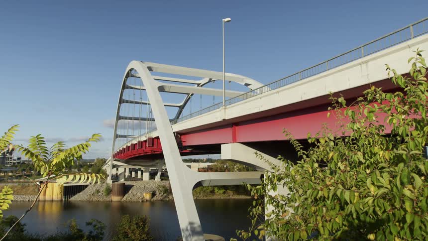 A red and white bridge over a calm river