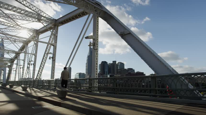 A man walks across the empty bridge
