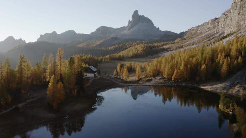 Aerial view of a lake and forest with a building on the shore