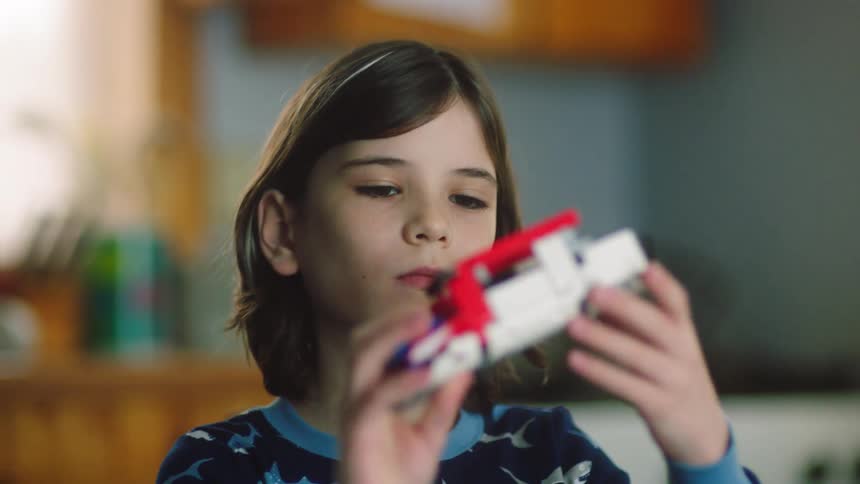 A boy is playing with a toy in the kitchen