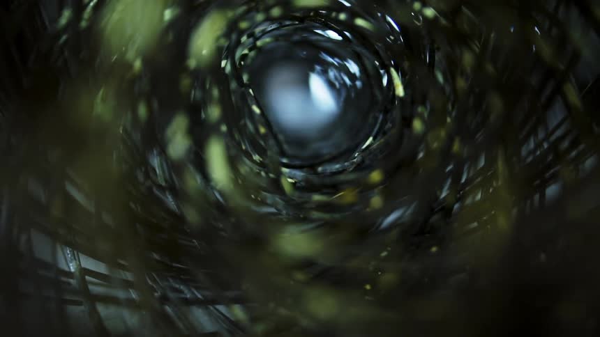 Light shimmers and glows inside rolled up fencing creating a tunnel
