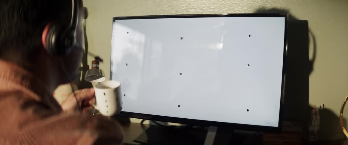 A man is typing on a computer while sitting on a desk