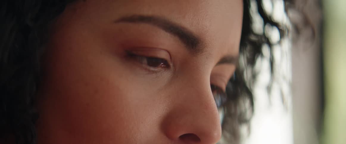 A black woman nods her head while scanning with her eyes