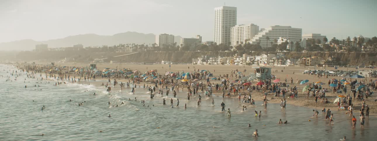 Aerial of large crowds enjoying a day at the beach