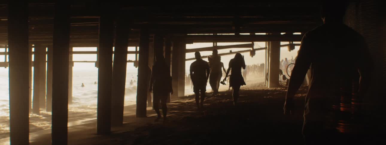 People walking under a pier