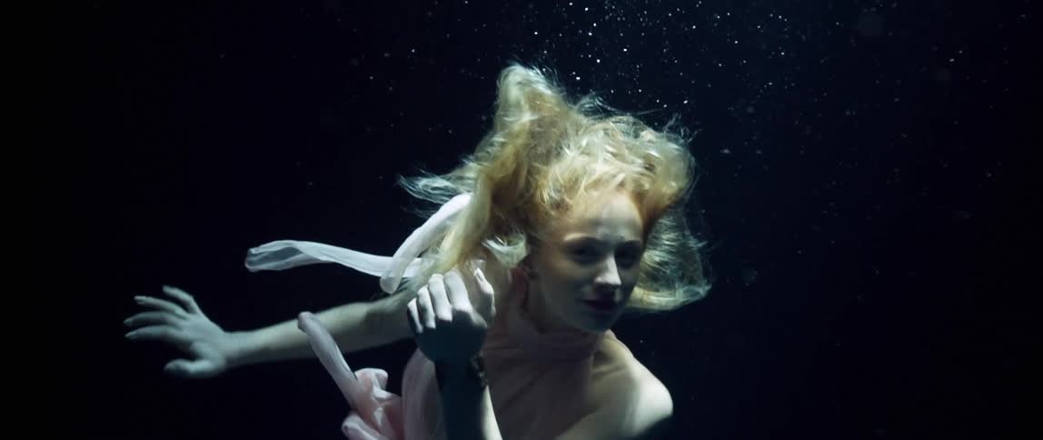 A fully clothed woman swimsunderwater