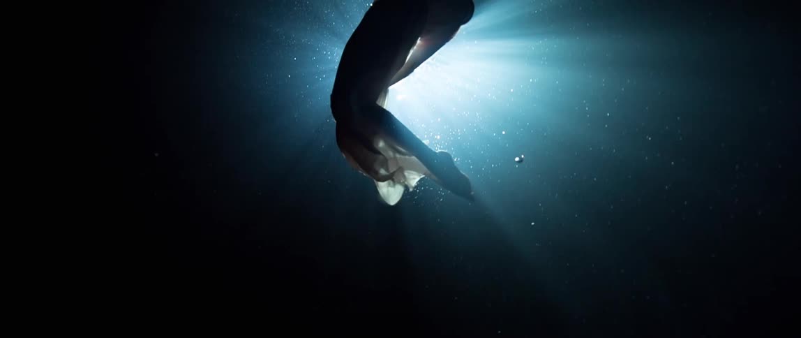 A fully clothed woman swims under water
