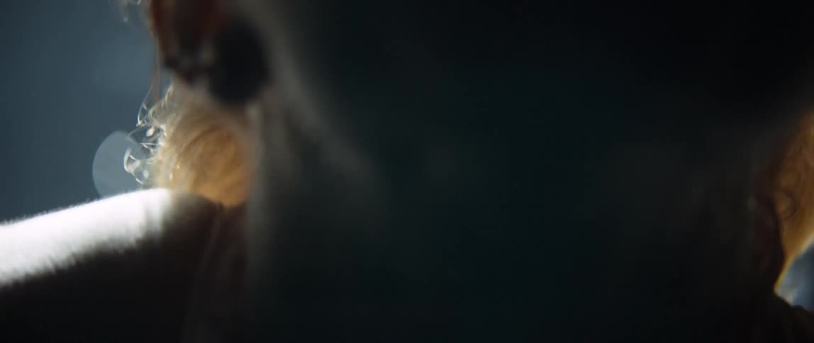 A blonde white woman swims underwater